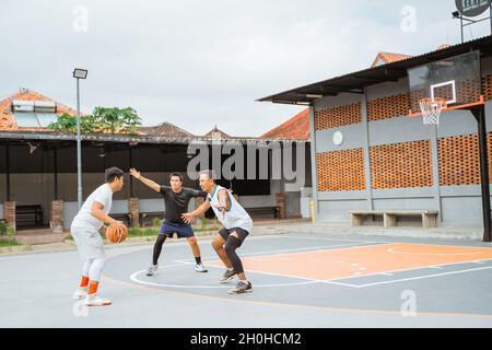 un giocatore che dribbling la palla attacca e due giocatori avversari si intromette Foto Stock