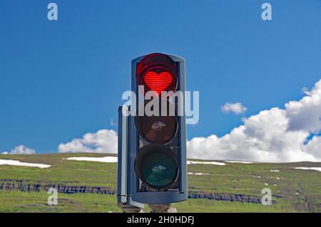 Semafori con cuore rosso, montagne sullo sfondo, Akureyri, Islanda Foto Stock