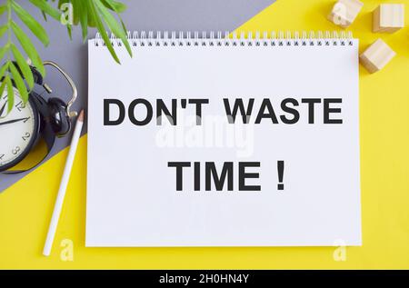 Non perdere il tempo scritto con sveglia e carta spazzatura su sfondo bianco. Preventivo aziendale. Messa a fuoco selettiva. Foto Stock