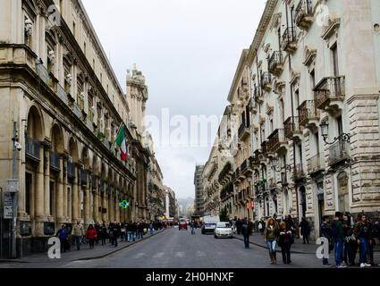 Catania, Italia. Via Etnea si snoda direttamente da Piazza del Duomo fino ai piedi dell'Etna. Fiancheggiata da negozi, bar e caffetterie sul marciapiede. Foto Stock