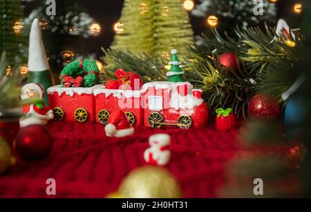 Treno di Natale e decorazioni su lana di filato rosso. Foto Stock