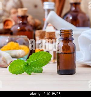 Fresco verde menta e olio essenziale con la profondità di campo di una configurazione su sfondo di legno . Foto Stock