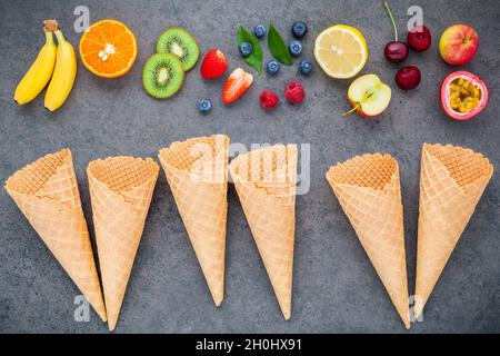 Lay piatto vari frutti ,Lampone Mirtillo ,fragola ,orange ,banana ,il frutto della passione ,apple e setup di ciliegio scuro su sfondo di pietra . Estate e Foto Stock