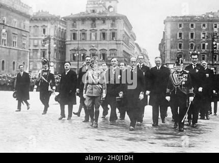 Il re d'Italia, Vittorio Emanuele III (Centro, in uniforme), ha incontrato pubblicamente Benito Mussolini (destra), il nuovo capo del governo, il 4 novembre 1922. Essi sono seguiti dal nuovo gabinetto installato sulla strada per la Tomba del Milite Ignoto, dopo che i ministri avevano giurato in precedenza i loro giuramenti inaugurali. Alcuni ministri (da sinistra a destra): Probabilmente Gabriello Carnazza (Ministro dei lavori pubblici, a sinistra dietro il Re), Luigi Federzoni (Ministro degli affari coloniali, alle spalle del Re) Giuseppe De Capitani d'Arzago (Ministro dell'Agricoltura, 2° da sinistra dietro Mussolini) e Grand Foto Stock