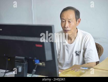 (211013) -- CHENGDU, 13 ottobre 2021 (Xinhua) -- Yin Kaipu lavora nel suo ufficio a Chengdu, provincia sudoccidentale del Sichuan della Cina, 2 ottobre 2021. Yin, un ecologo famoso di 78 anni in Cina, si dedica alla protezione della biodiversità da oltre sei decenni. Dopo essersi laureato a scuola nel 1960, Yin ha lavorato presso il Chengdu Institute of Biology dell'Accademia Cinese delle Scienze (CAS), occupandosi principalmente di indagini e conservazione delle risorse biologiche. Nel 1978, Yin propose di creare le riserve naturali di Jiuzhaigou e di Yading per evitare che vengano distrutte. Oggi, Jiu Foto Stock