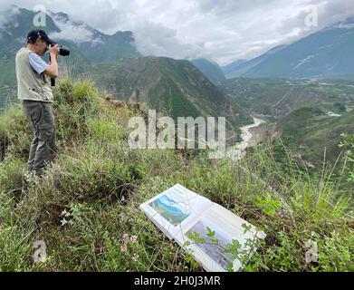 (211013) -- CHENGDU, 13 ottobre 2021 (Xinhua) -- Foto di archivio scattata nel giugno 2020 mostra Yin Kaipu scattando foto durante una ricerca scientifica nella contea di Maoxian, provincia sudoccidentale della Cina di Sichuan. Yin, un ecologo famoso di 78 anni in Cina, si dedica alla protezione della biodiversità da oltre sei decenni. Dopo essersi laureato a scuola nel 1960, Yin ha lavorato presso il Chengdu Institute of Biology dell'Accademia Cinese delle Scienze (CAS), occupandosi principalmente di indagini e conservazione delle risorse biologiche. Nel 1978, Yin propose di stabilire la riserva naturale Jiuzhaigou e Yading Foto Stock