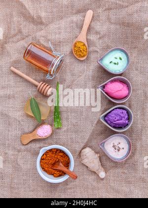 Alternative di cura per la pelle e scrub fatti in casa con ingredienti naturali salvia ,curcuma ,sale di mare ,miele, aloe vera,limone ,rosmarino,menta e sesamo su marrone Foto Stock