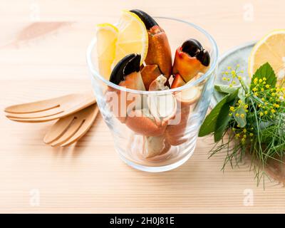 Freschi cotti al vapore granchi rossi della gamba in recipiente di vetro . Gamberi rossi gamba con ingredienti. Vaporizzato granchi rossi gamba con erbe aromatiche finocchio ,prezzemolo,rosmarino,limone e menta w Foto Stock