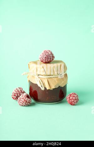 Vasetto di marmellata di lamponi con ingredienti su sfondo menta Foto Stock