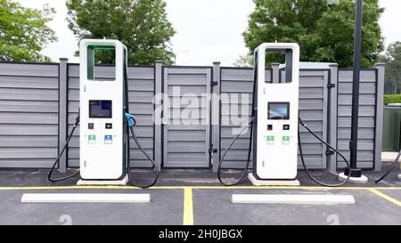 Primo piano di una stazione di ricarica elettrica con due caricabatterie elettrici bianchi Foto Stock