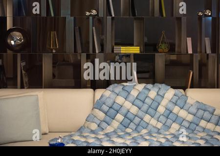 Elegante lounge alla moda con scaffale scuro e morbido divano Foto Stock