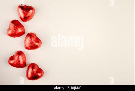 vista dall'alto di caramelle rosse a forma di cuore isolate su sfondo bianco con spazio per la copia Foto Stock