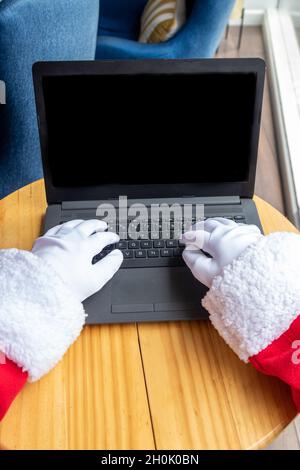 Babbo Natale digitando dal suo taccuino Foto Stock