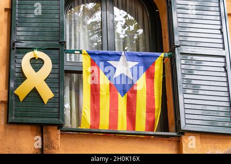 Bandiera d'indipendenza catalana e nastro giallo appeso a una finestra che chiede l'indipendenza della Catalogna e la libertà del politico imprigionato Foto Stock