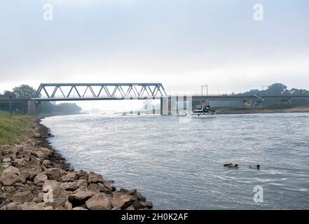 ponte sul fiume ijssel con barche a deventer città olandese in mattina nebbia Foto Stock