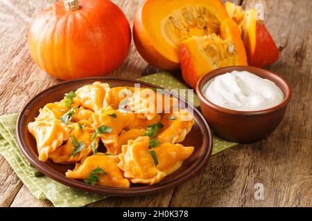 Gnocchi di zucca autunnali tradizionali primo piano su un piatto sul tavolo. Orizzontale Foto Stock