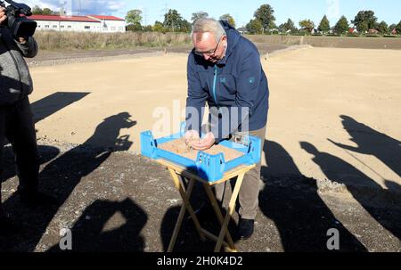 Roggentin, Germania. 13 ottobre 2021. Till Backhaus (SPD), ministro dell'Agricoltura di Meclemburgo-Pomerania occidentale, si trova in una scatola di allevamento con 10,000 vermi dopo la cerimonia simbolica di rottura per un impianto di produzione di farine di insetti della giovane società di start-up con sede a Rostock Inova Protein. In futuro, 1.5 tonnellate di farine di insetti al mese saranno prodotte a partire da vermi di palma nel locale di produzione, che misura poco meno di 800 metri quadrati. A maggio, il verme giallo (Tenebrio molitor) è stato il primo insetto approvato dall'UE come nuovo prodotto alimentare. Credit: Bernd/dpa/Alamy Live News Foto Stock