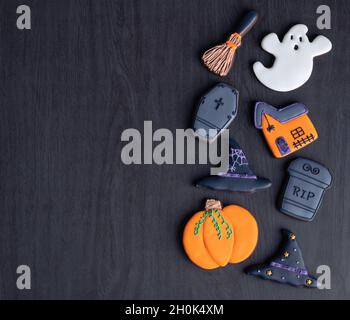 Halloween pani di zenzero, zucca, fantasma, cappello di strega, tombstone su sfondo di legno scuro con spazio copia. Foto Stock