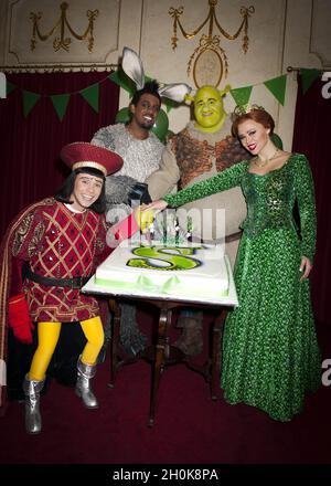 Neil McDermott che suona Lord Farquaad, Richard Blackwood che suona l'asino, Dean Chisnell che suona Shrek e Kimberley Walsh che suona la principessa Fiona ha tagliato la torta a Shrek il Fete della famiglia di 1 anno di anniversario musicale al Drury Lane Theatre di Londra Foto Stock
