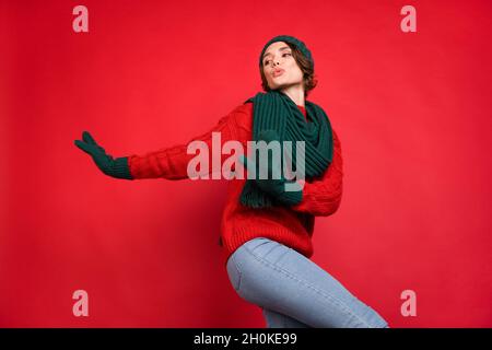 Foto ritratto giovane donna che balla a festa in sciarpa mittens isolato vibrante rosso sfondo di colore Foto Stock