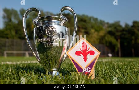 30 agosto 2021, Firenze, Italia. L'emblema della squadra di calcio ACF Fiorentina e della UEFA Champions League Cup su un prato verde. Foto Stock