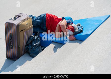 MOSCA, RUSSIA - 31 agosto 2021: Mosca, Russia, un uomo senza tetto stanco dorme sui gradini del sole Foto Stock