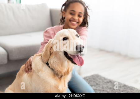Giovane ragazza nera che gioca con il cane, fuoco selettivo sull'animale domestico Foto Stock