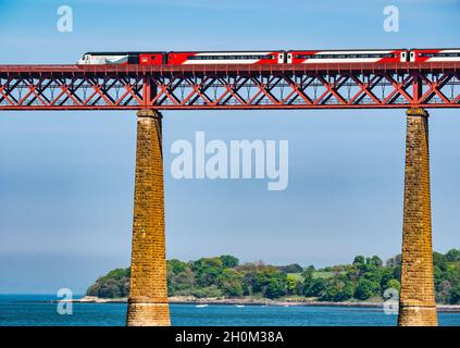 Treno LNER attraversando iconico Ponte di Forth Rail su Firth of Forth sulla giornata di sole, Scotland, Regno Unito Foto Stock