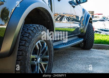 vista ravvicinata posteriore dell'auto fuoristrada su ruote grandi sporche Foto Stock