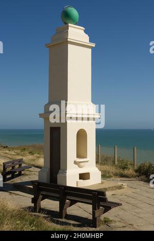 Re George V. Memorial marking primo meridiano di Greenwich datato 1936 a Peacehave nel Sussex orientale, Inghilterra. Con canale inglese dietro. Foto Stock