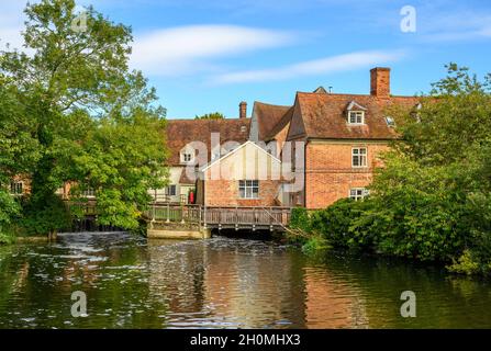 Gli edifici in mattoni rossi di Flatford Mill si affacciano dall'altra parte del fiume Stour nel 'Paese Constable', Suffolk, Inghilterra. Foto Stock