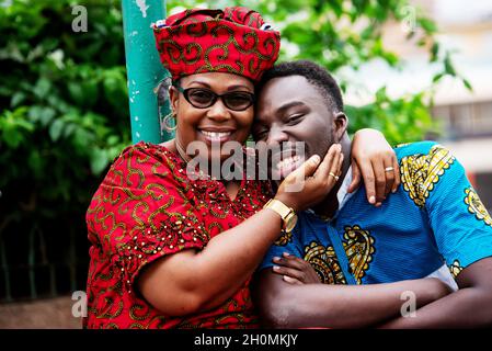 ritratto di giovane uomo e donna che abbraccia la strada e guarda la macchina fotografica sorridente Foto Stock