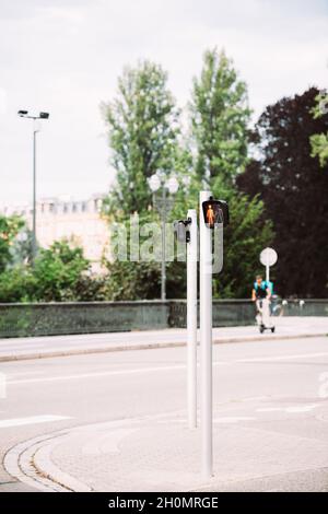 Traversa rossa Street con silhouette sfocata dell'uomo sullo scooter Foto Stock