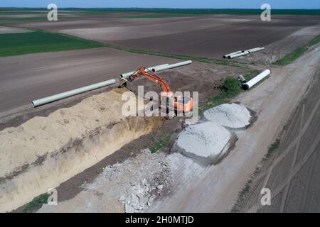 Immagine aerea della fossa di scavo dell'escavatore per la linea di teleriscaldamento sul campo Foto Stock