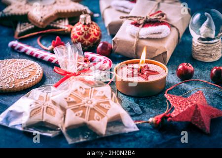 Regali natalizi con scatole, caramelle e biscotti al pan di zenzero su sfondo blu scuro Foto Stock