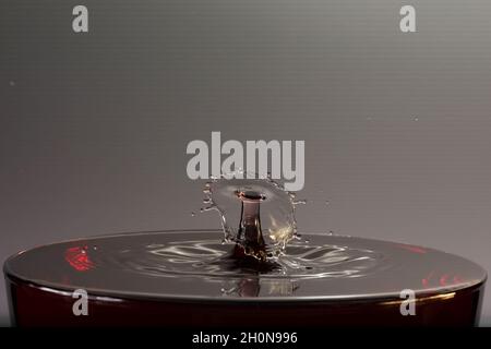 Gocce d'acqua su una superficie d'acqua che provocano sculture d'acqua. Foto Stock