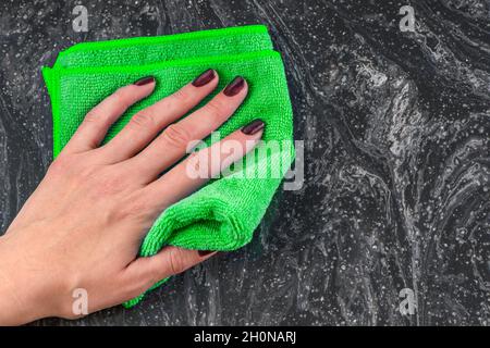 Pulizia del piano di lavoro. Cura dei countertops nella cucina o nella stanza da bagno. Pulizia di superfici in pietra, marmo o pietra artificiale. Salviette per le mani da donna Foto Stock