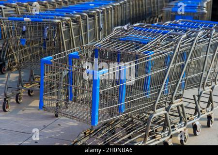 File di carrelli per lo shopping vicino all'ingresso del supermercato Foto Stock