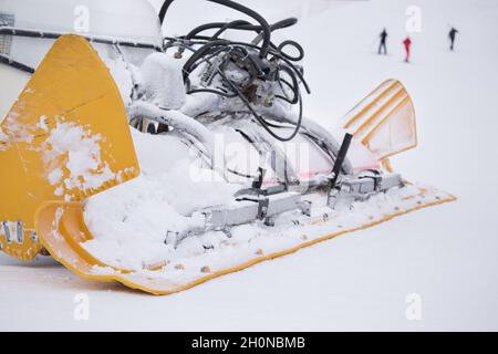 Primo piano della macchina per la preparazione delle piste da sci parcheggiate sulla neve Foto Stock