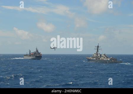 211010-N-EF547-1003 OCEANO INDIANO (OTT 10, 2021) Arleigh Burke-class cacciatorpediniere missilistico guidato USS Stockdale (DDG 106) conduce un rifornimento verticale con HMAS Sirius (o 266) durante un esercizio bilaterale con Royal Australian Navy HMAS Ballarat Strike Group, 10 ottobre 2021. Carl Vinson Carrier Strike Group è in fase di implementazione nell'area operativa della 7a flotta statunitense per migliorare l'interoperabilità attraverso alleanze e partnership, fungendo da forza di risposta pronta a supportare una regione indopacifica libera e aperta. (STATI UNITI Foto della Marina di Ensign Sarah Weinstein) Foto Stock