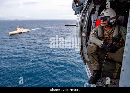 211011-N-PH222-2120 SULU SEA (OTT 11, 2021) Naval Air Crewman (Helicopter) II Javier Rosas, di San Mateo, California, siede in un elicottero MH-60 Seahawk, assegnato ai "Blackjack" di Helicopter Sea Combat (HSC) Squadron 21, durante le operazioni di volo di routine con la nave da combattimento litoranea variante Independence USS Charleston (LCS 18). Charleston, parte di Destroyer Squadron Seven, è in fase di implementazione rotazionale, sta operando nell'area operativa della settima flotta degli Stati Uniti per migliorare l'interoperabilità con i partner e fungere da forza di risposta pronta a sostegno della regione indopacifica libera e aperta. (STATI UNITI NAV Foto Stock