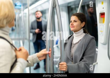 Due passeggeri donne che parlano in auto metropolitana in viaggio di lavoro Foto Stock