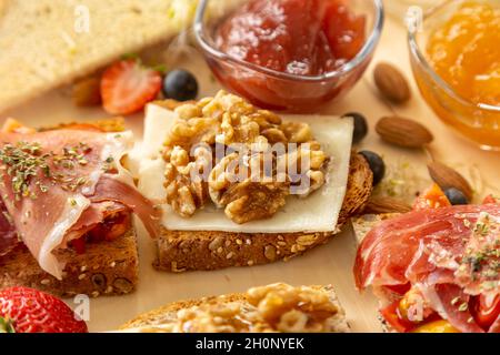 Bruschetta assortita appetitosa con vari condimenti su un tavolo di legno Foto Stock