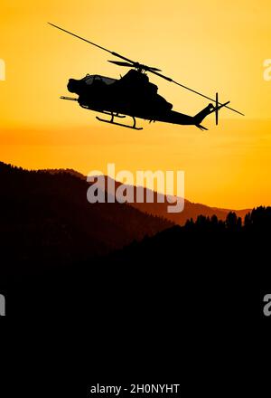 American Attack elicottero silhouette in volo Foto Stock