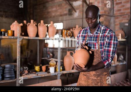 Artigiano che esamina la terracotta fatta a mano Foto Stock