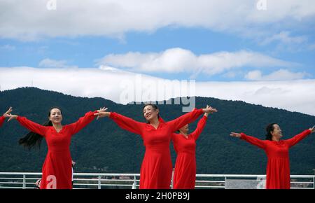 Kunming, provincia cinese di Yunnan. 13 ottobre 2021. I cittadini ballano vicino al lago Dianchi a Kunming, provincia dello Yunnan della Cina sudoccidentale, 13 ottobre 2021. Credit: Yahui/Xinhua/Alamy Live News Foto Stock