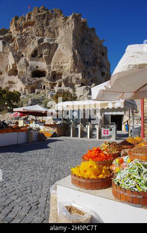 In primo piano vendita di frutta secca e sullo sfondo il castello di Uchisar, Valle dei piccioni, Cappadocia, Turchia Foto Stock