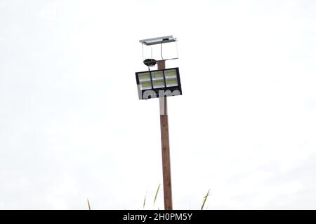 Una luce solare sportiva è stata installata su un palo per illuminare l'area di copertura di notte. La luce solare sportiva è utilizzata per illuminare il negozio di costruzioni di notte. Foto Stock