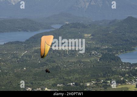 Gente parapendio sul lago Nahuel Huapi e le colline circostanti nella Patagonia settentrionale, Argentina Foto Stock