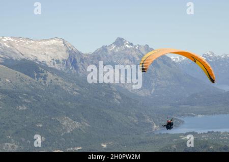 Gente parapendio sul lago Nahuel Huapi e le colline circostanti nella Patagonia settentrionale, Argentina Foto Stock